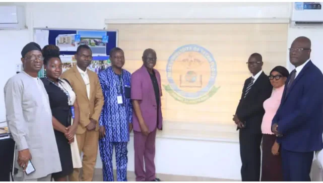 Academy and Bells University of Technology delegates before the institutional crest